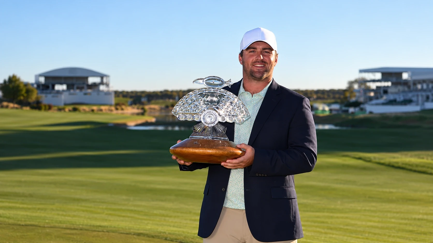 Chris Gotterup holding a trophy on the course after a PGA Tour win